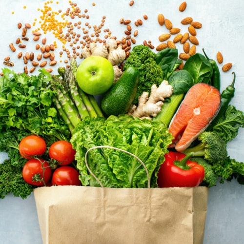 Top down view on a variety of fresh produce in a paper bag